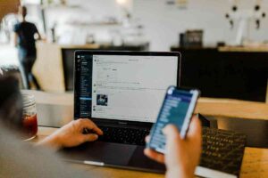 Uomo con lo smartphone davanti al pc